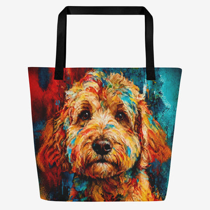 A tote bag with black handles featuring a colorful, textured painting of a goldendoodle's face in warm orange, yellow, and red tones against a light gray background.