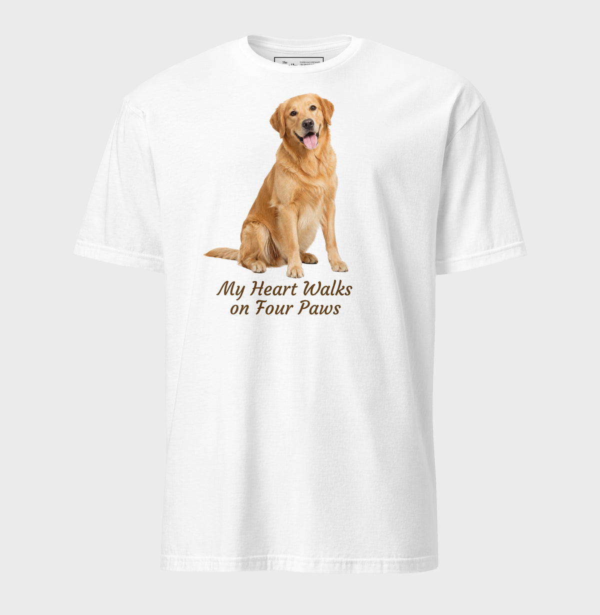 A white short-sleeve crewneck t-shirt featuring a graphic of a golden retriever dog sitting down with the text 'My Heart Walks on Four Paws' printed below it.