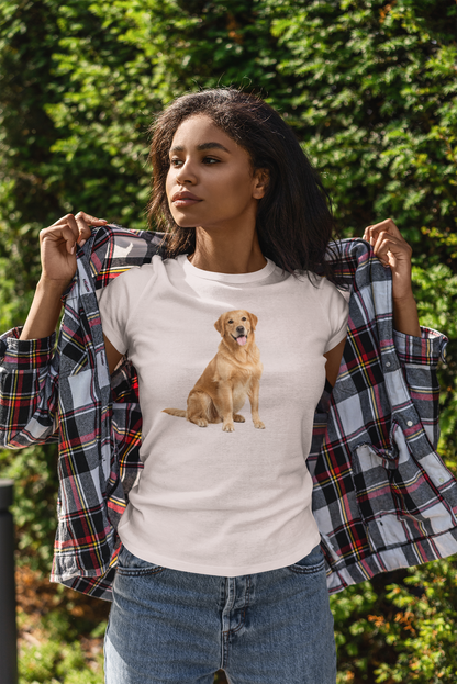 A woman outdoors wearing an ice gray t-shirt with a graphic of a golden retriever dog, holding open a plaid flannel shirt over her shoulders. She is wearing blue jeans, with a background of green foliage.