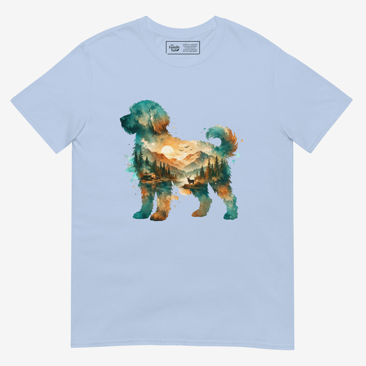 A light blue short-sleeve crewneck t-shirt featuring a watercolor-style graphic of a goldendoodle dog silhouette filled with a scenic landscape of mountains, trees, and a lake.